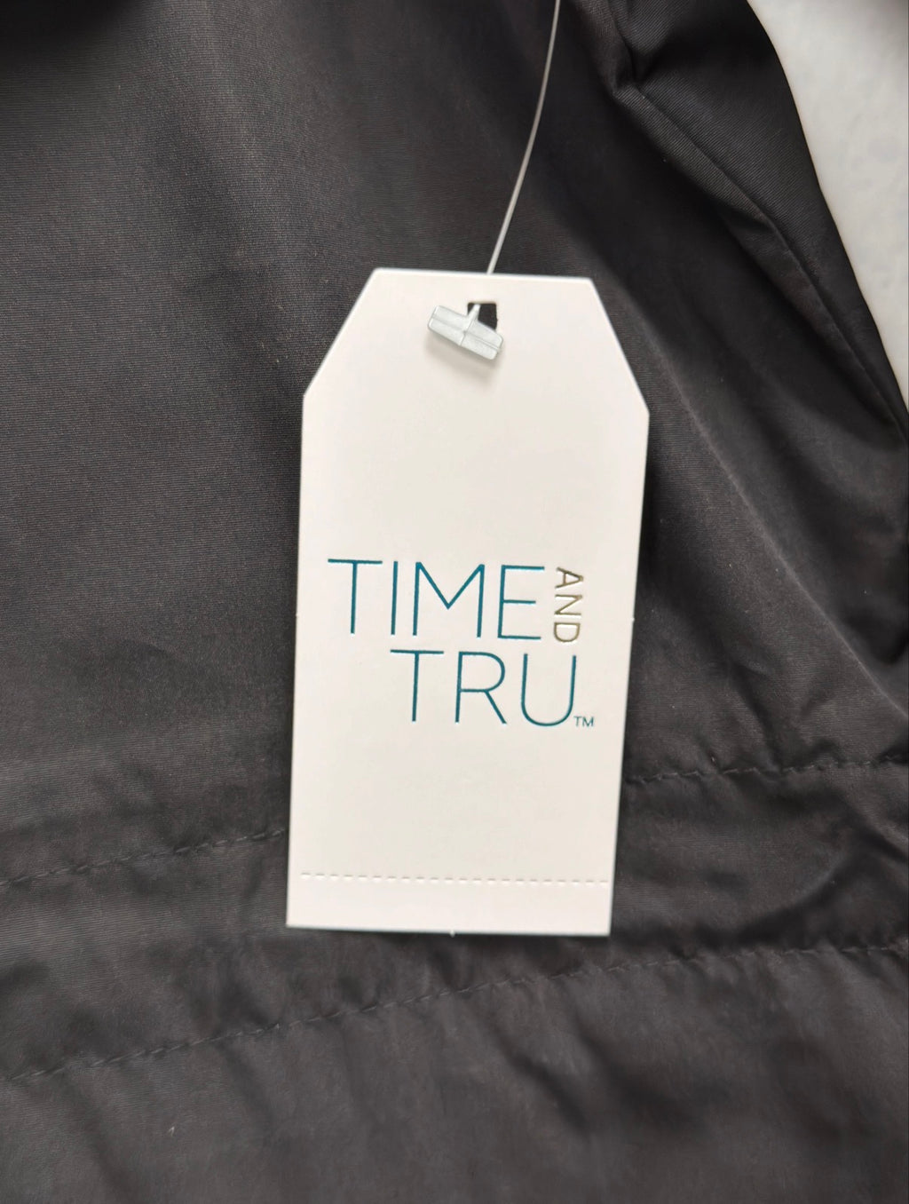 Time and Tru hang tag on black rain jacket