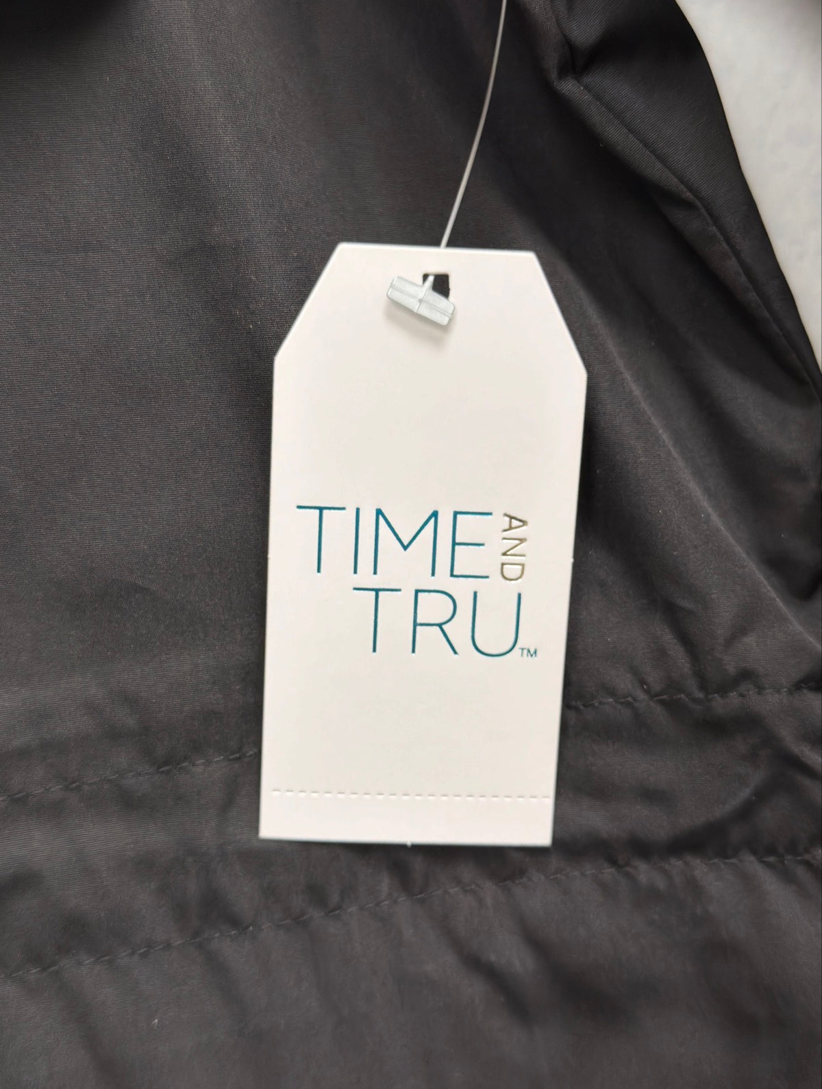 Time and Tru hang tag on black rain jacket